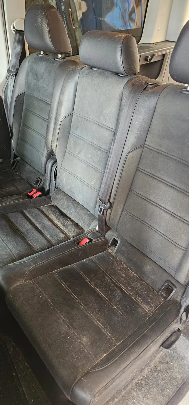 Sitzreihe desselben Fahrzeugs vor der Polsterreinigung: Alcantara mit grauem Staubfilm