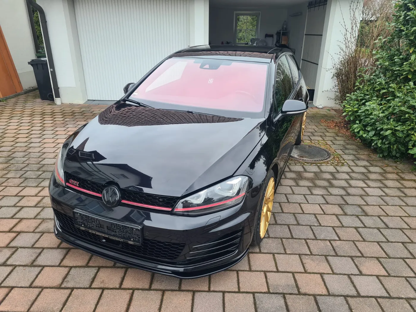 Schwarzer VW Golf GTI mit Hochglanz-Lack und goldenen Felgen