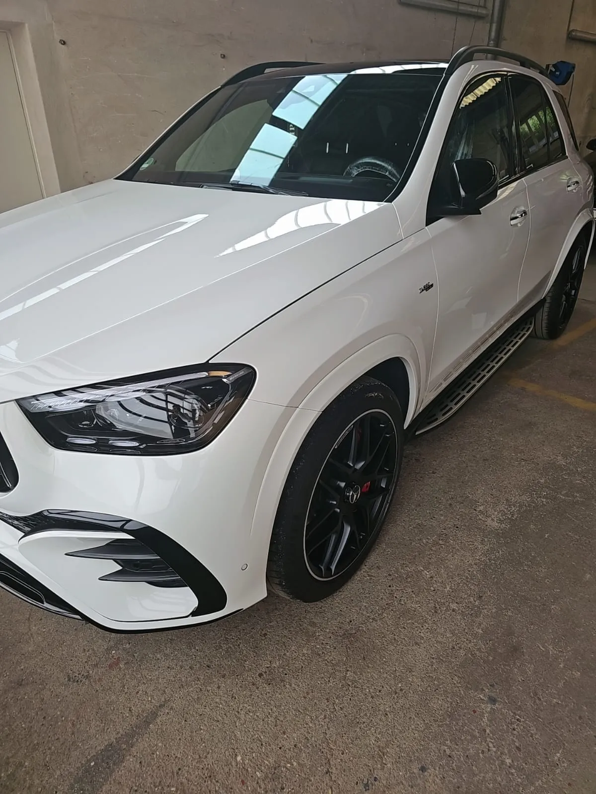 Frisch gewaschener weißer Mercedes-Benz SUV mit Hochglanz-Lack in der Halle