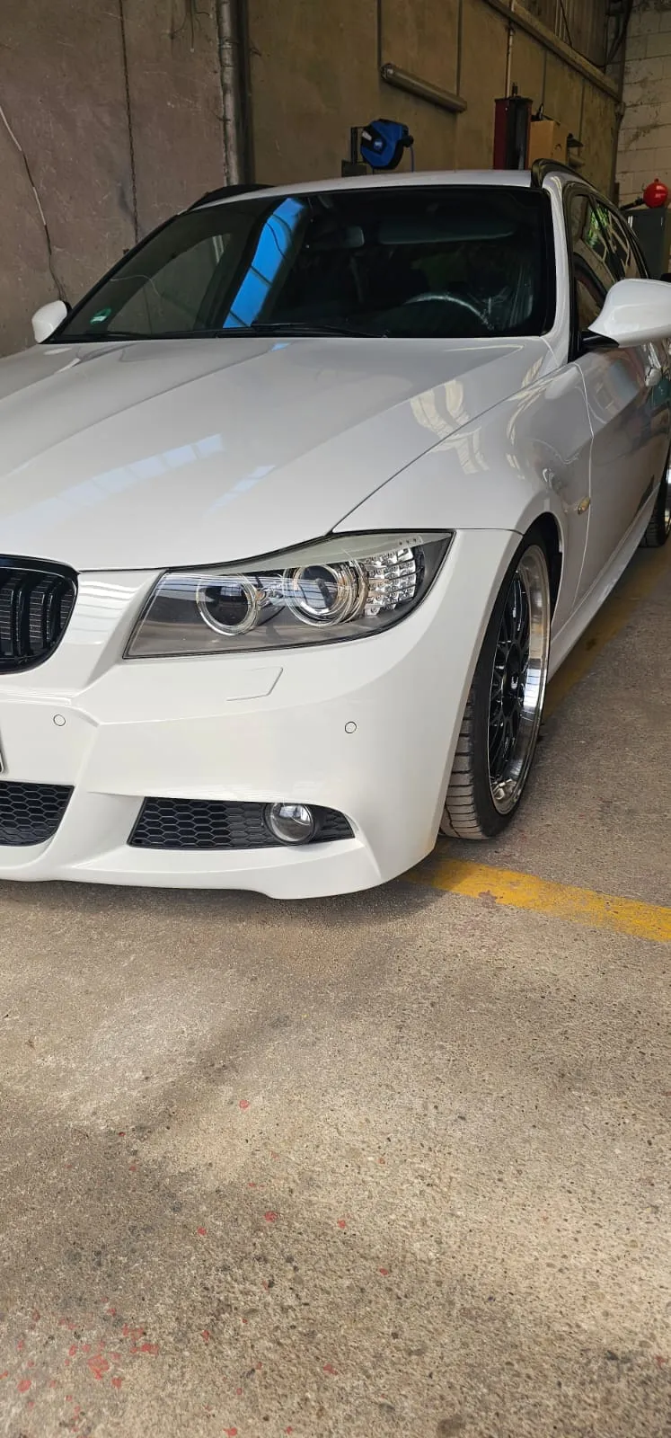 Frisch aufbereiteter weißer BMW in Frontansicht in der Garage